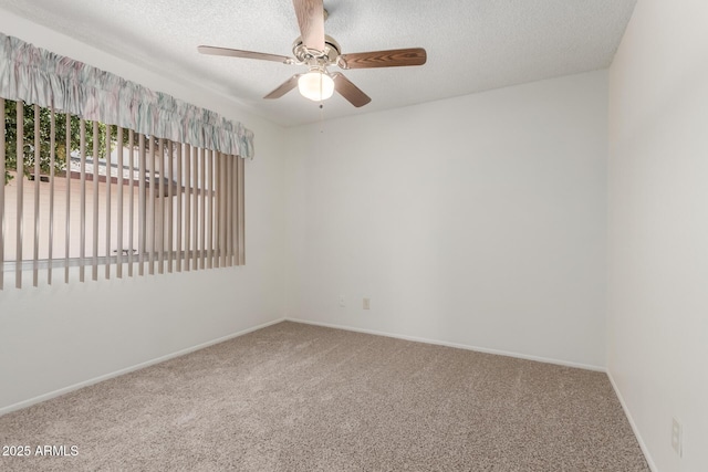 carpeted empty room with a ceiling fan, baseboards, and a textured ceiling