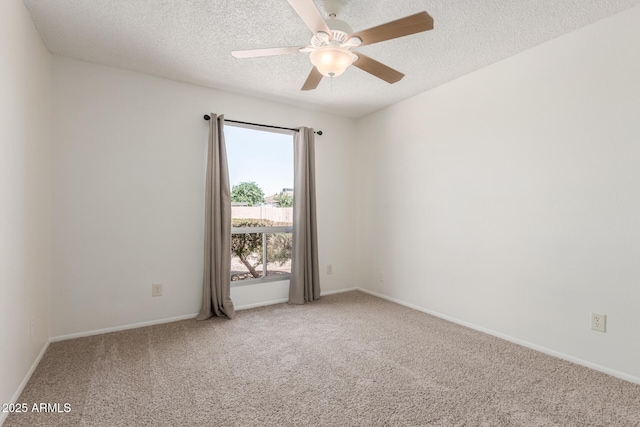 carpeted spare room featuring baseboards, ceiling fan, and a textured ceiling