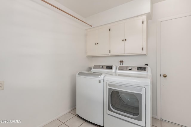 washroom featuring baseboards, cabinet space, light tile patterned flooring, and washing machine and clothes dryer