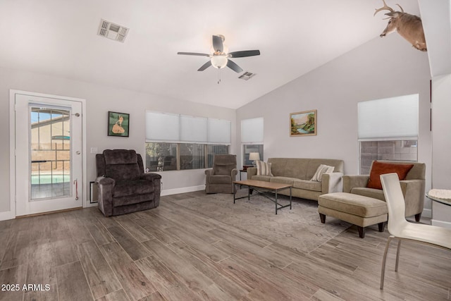 living room with ceiling fan, hardwood / wood-style floors, and vaulted ceiling