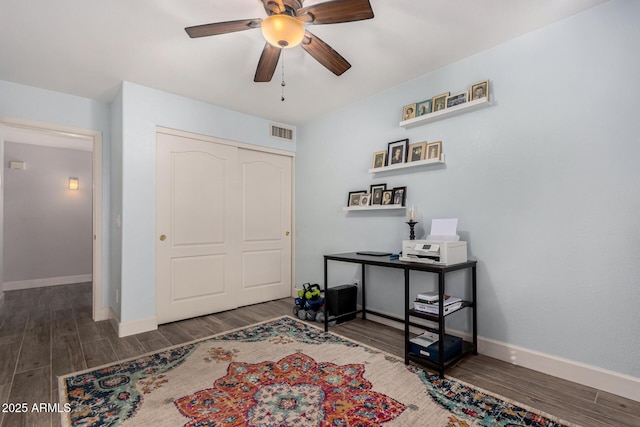 interior space featuring dark wood-type flooring, ceiling fan, and a closet