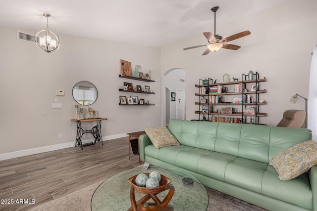 living room featuring ceiling fan with notable chandelier and hardwood / wood-style flooring