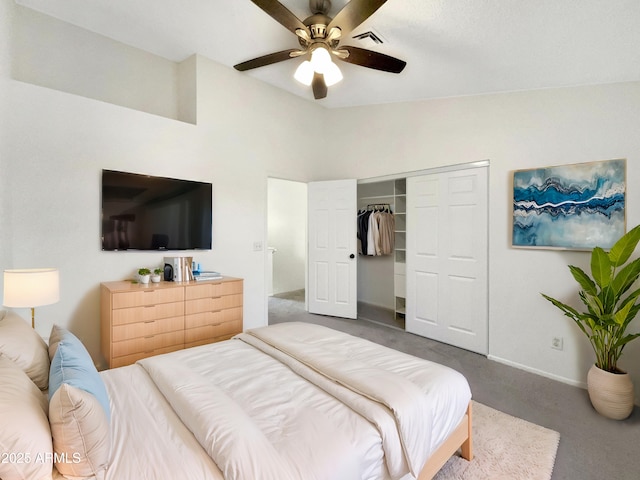 carpeted bedroom with ceiling fan, vaulted ceiling, and a closet