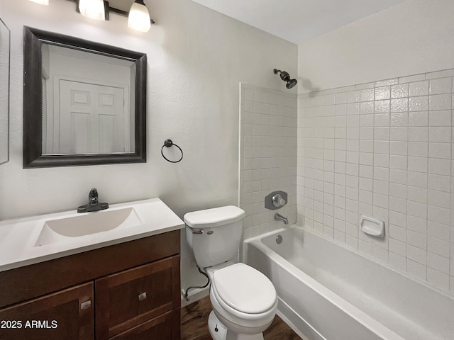 full bathroom with toilet, vanity, and tiled shower / bath