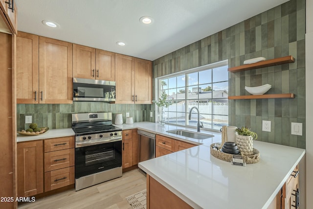 kitchen featuring sink, backsplash, stainless steel appliances, and light wood-type flooring