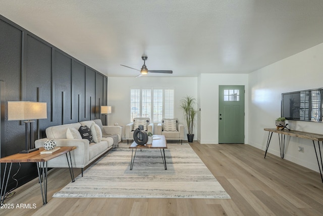 living room featuring ceiling fan and light hardwood / wood-style floors