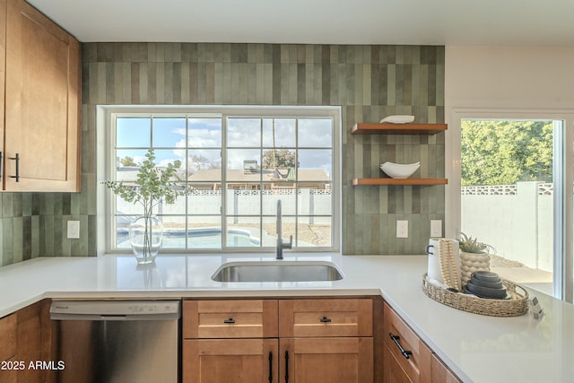 kitchen featuring tasteful backsplash, dishwasher, and sink