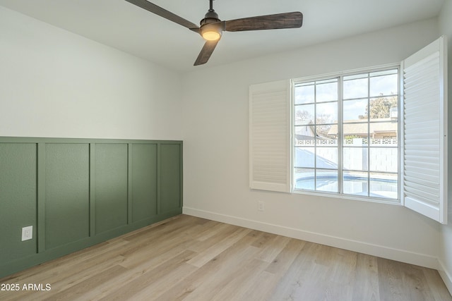 empty room with ceiling fan and light hardwood / wood-style flooring