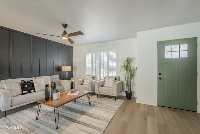 living room featuring ceiling fan and light hardwood / wood-style flooring