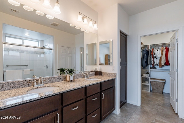 full bathroom featuring a sink, visible vents, a stall shower, and double vanity