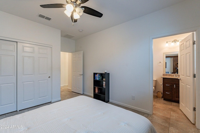 tiled bedroom with ensuite bathroom, ceiling fan, and a closet