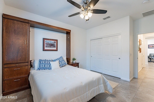 tiled bedroom featuring ceiling fan and a closet