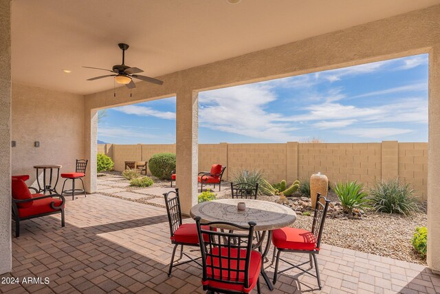 view of patio featuring ceiling fan, outdoor dining area, and a fenced backyard