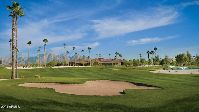 view of property's community with a mountain view, golf course view, and a yard