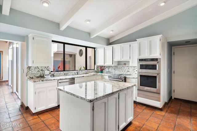 84 Biltmore Est, Phoenix, AZ 85016 - kitchen with light stone countertops, tasteful backsplash, white cabinetry, a center island, and appliances with stainless steel finishes