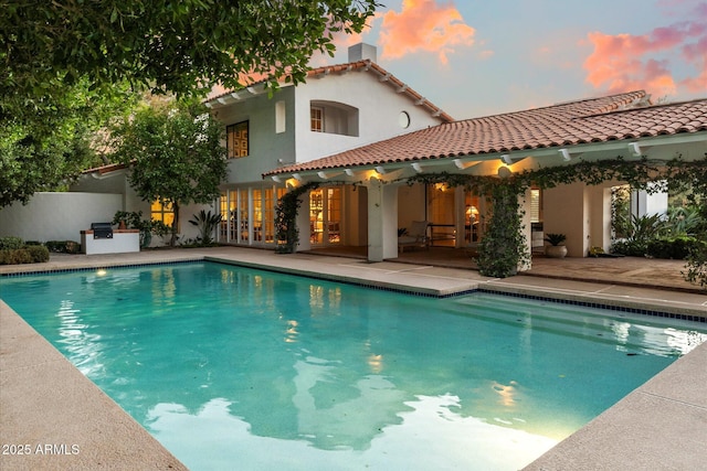 84 Biltmore Est, Phoenix, AZ 85016 - back of property at dusk featuring a patio area, a tile roof, and stucco siding