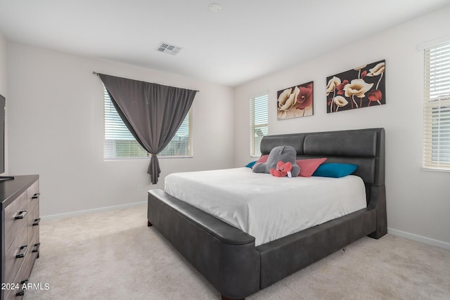 bedroom featuring visible vents, light carpet, baseboards, and multiple windows