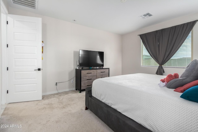 bedroom with visible vents, light carpet, and baseboards