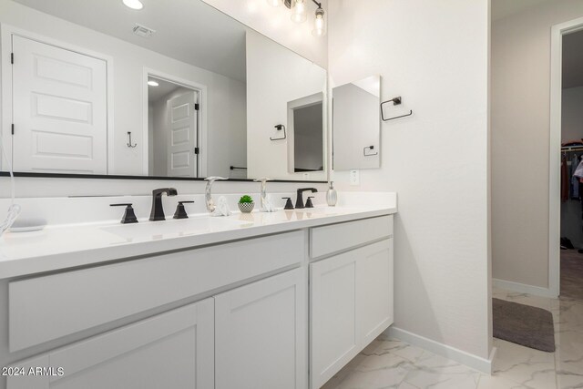 bathroom with double vanity, visible vents, baseboards, marble finish floor, and a sink