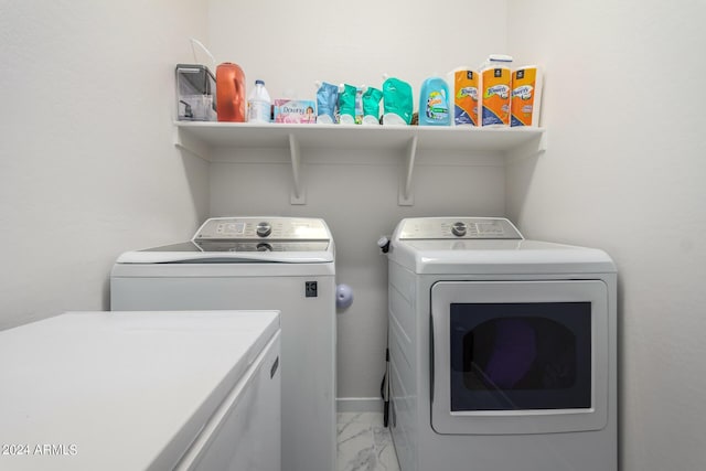 clothes washing area with marble finish floor, laundry area, and washer and dryer