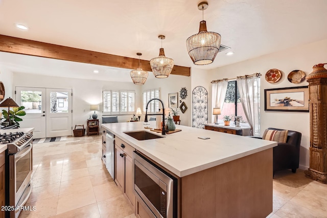 kitchen featuring stainless steel appliances, french doors, a sink, and light countertops