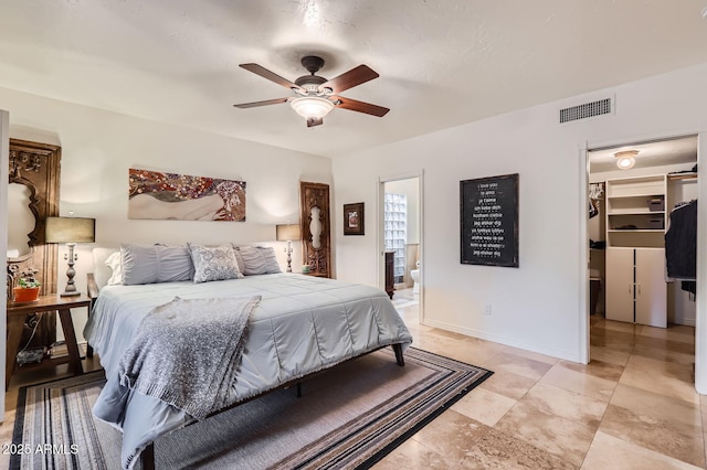 bedroom featuring visible vents, a spacious closet, connected bathroom, ceiling fan, and baseboards