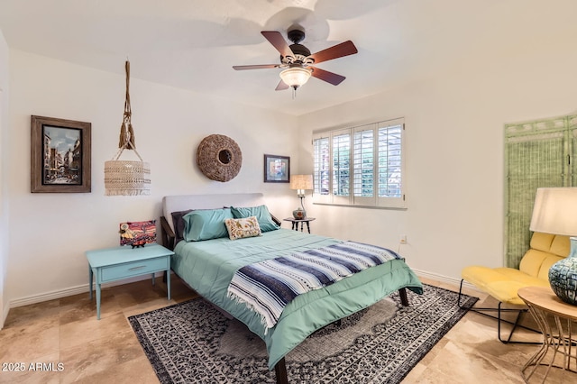 bedroom with ceiling fan and baseboards