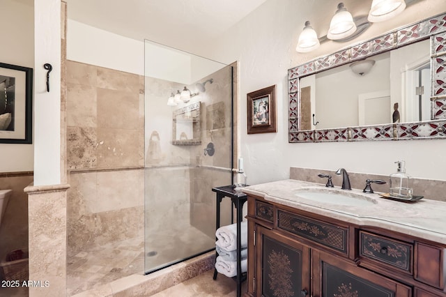 bathroom featuring a tile shower and vanity