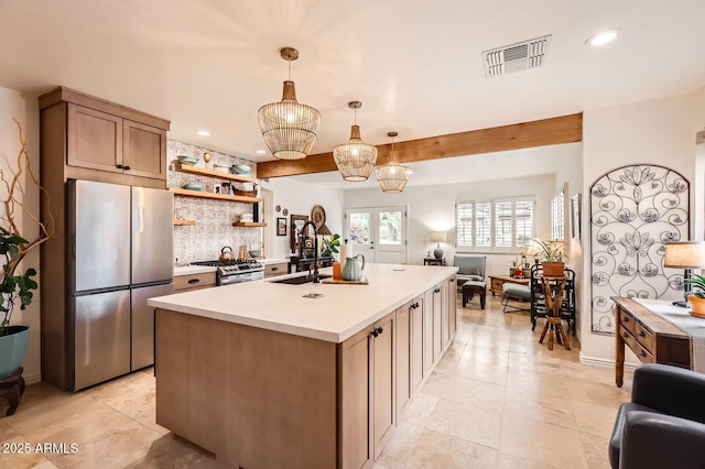 kitchen with visible vents, open floor plan, light countertops, stainless steel appliances, and a sink