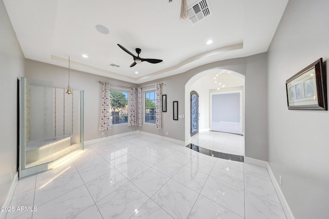 26204 S Washington St, Chandler, AZ 85249 - unfurnished room featuring a raised ceiling, ceiling fan, arched walkways, marble look tiles, and recessed lighting