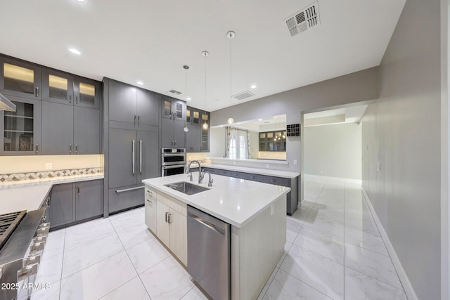 26204 S Washington St, Chandler, AZ 85249 - kitchen with stainless steel appliances, light marble finish floors, a center island with sink, gray cabinets, and decorative light fixtures