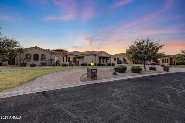 26204 S Washington St, Chandler, AZ 85249 - mediterranean / spanish house featuring curved driveway, stucco siding, a front lawn, and a tiled roof