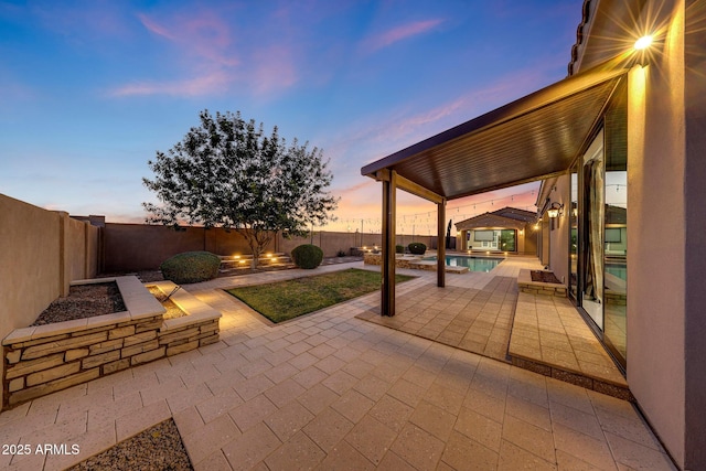 26204 S Washington St, Chandler, AZ 85249 - patio terrace at dusk featuring a patio area, a fenced backyard, and a pool with connected hot tub