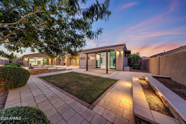 26204 S Washington St, Chandler, AZ 85249 - back of house at dusk with a patio area, a swimming pool, stucco siding, and a tiled roof