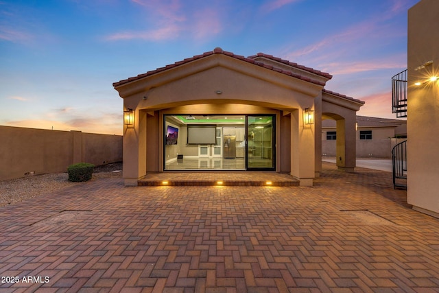 26204 S Washington St, Chandler, AZ 85249 - back of property at dusk featuring stucco siding, a fenced backyard, a tile roof, and a patio