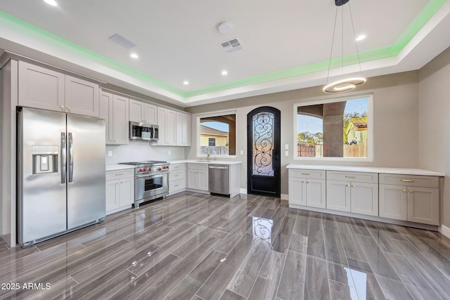 26204 S Washington St, Chandler, AZ 85249 - kitchen with stainless steel appliances, a tray ceiling, light countertops, pendant lighting, and recessed lighting