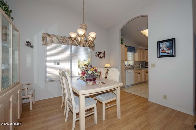 dining space with light hardwood / wood-style flooring, lofted ceiling, and an inviting chandelier