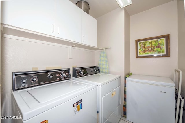 laundry area with cabinets and washer and clothes dryer