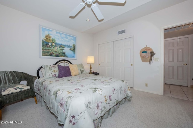 bedroom with ceiling fan, a closet, and light colored carpet