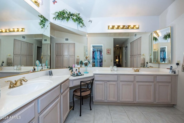 bathroom with tile patterned flooring, vanity, and vaulted ceiling