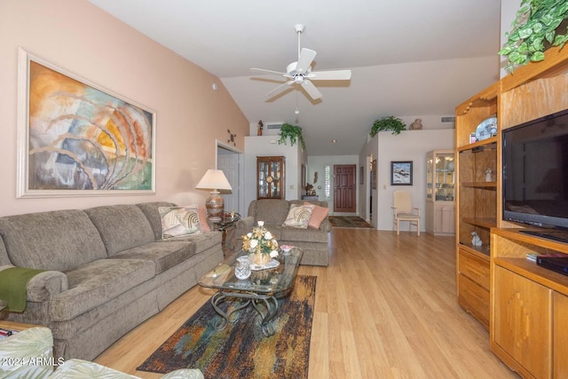 living room with ceiling fan, light hardwood / wood-style flooring, and vaulted ceiling