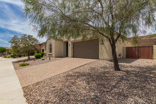 26860 N 102nd Ln, Peoria, AZ 85383 - view of front of house with fence, decorative driveway, stucco siding, a gate, and an attached garage