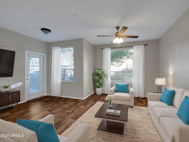 living room with a wealth of natural light, baseboards, a ceiling fan, and wood finished floors