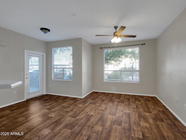 empty room featuring baseboards, plenty of natural light, wood finished floors, and a ceiling fan