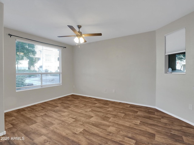 empty room featuring ceiling fan, baseboards, and wood finished floors