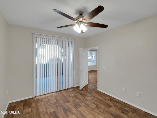 spare room featuring a ceiling fan, wood finished floors, and baseboards