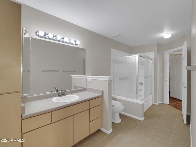 full bath featuring vanity, visible vents, shower / bath combination with glass door, tile patterned flooring, and toilet