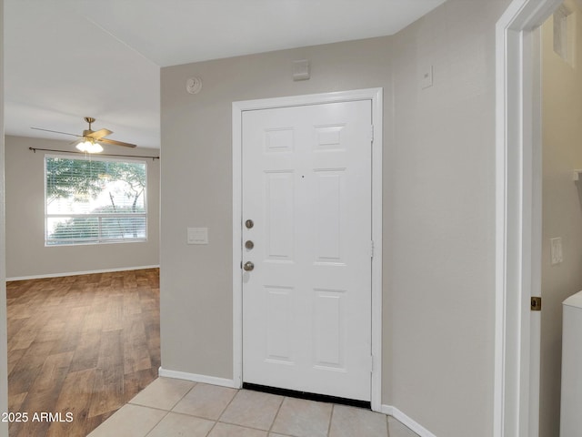 entryway featuring light tile patterned floors, baseboards, and ceiling fan