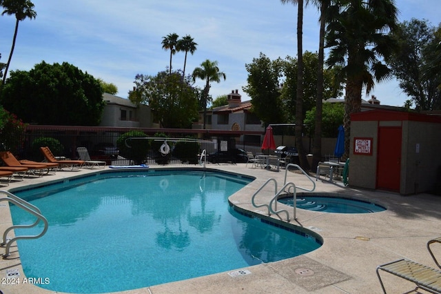 pool with a patio area and fence