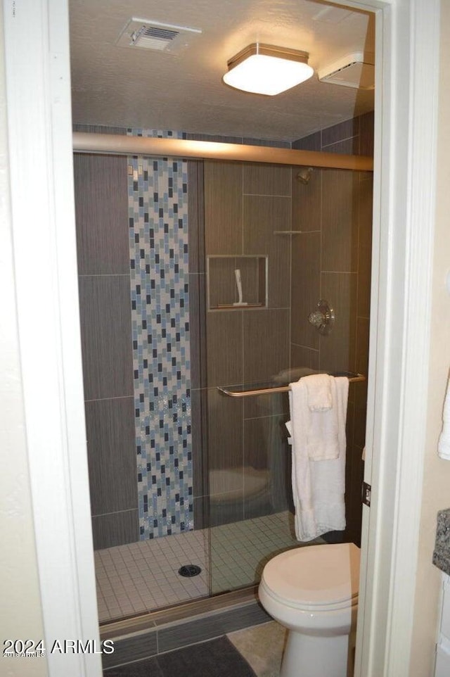 bathroom with visible vents, a stall shower, and toilet